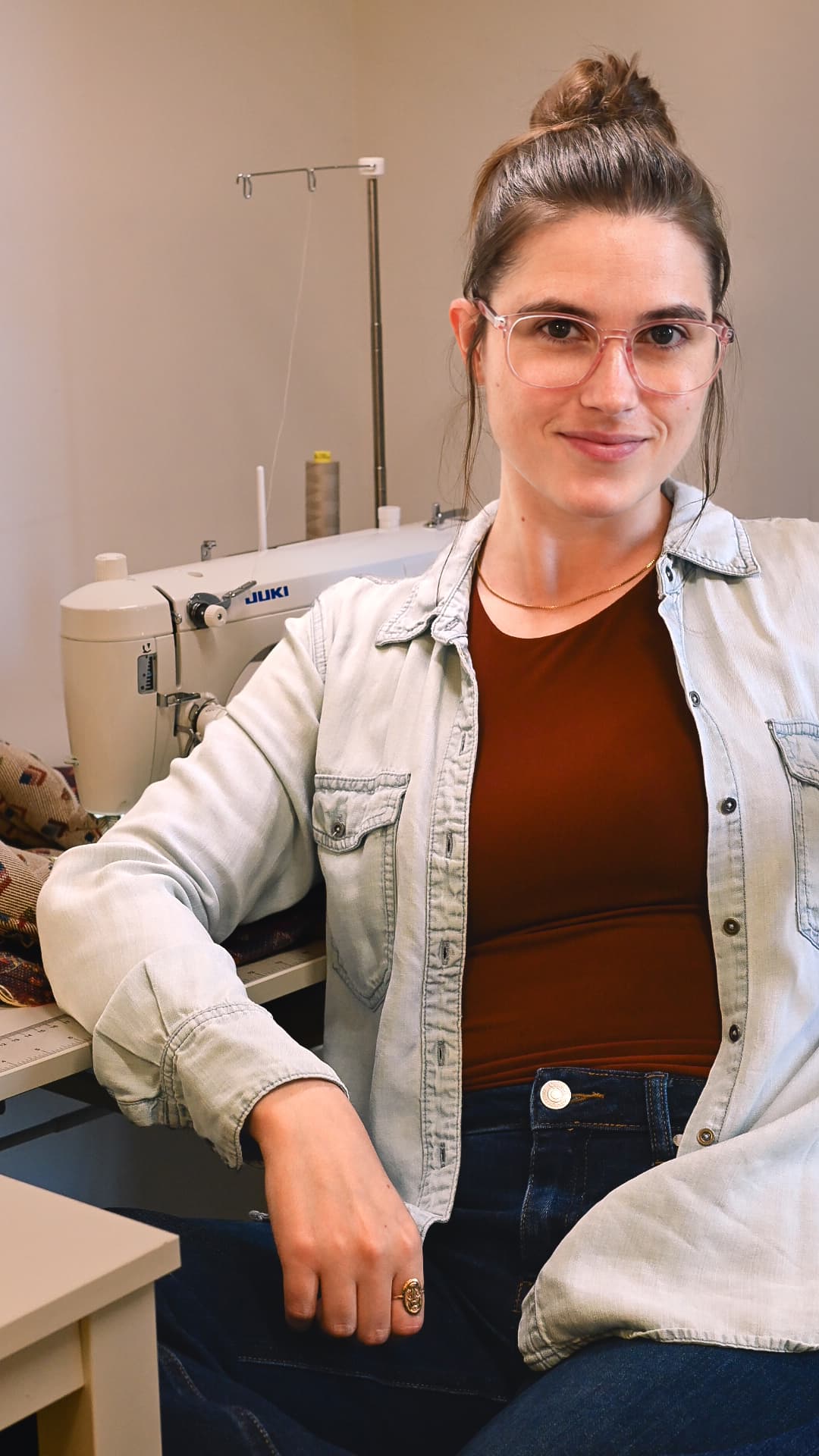 Candace, founder of The Salv, seated beside her sewing machine in the studio.
